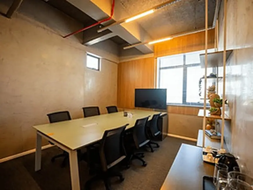 Sala de aula da Wind Connection com mesa de reunião, cadeiras e tela na parede